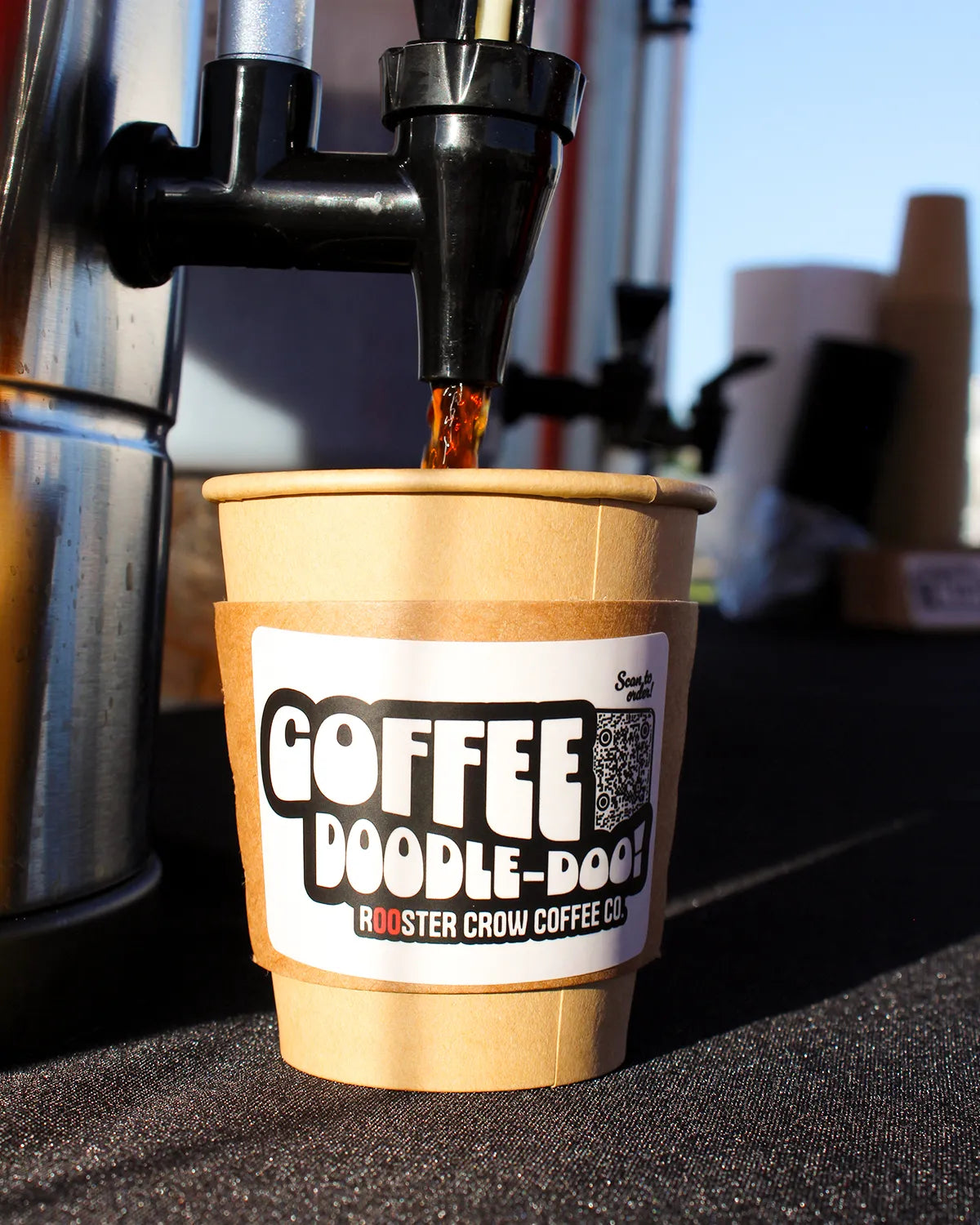 Pouring a fresh cup of Rooster Crow Coffee at a local market, showcasing our artisanal coffee and community engagement